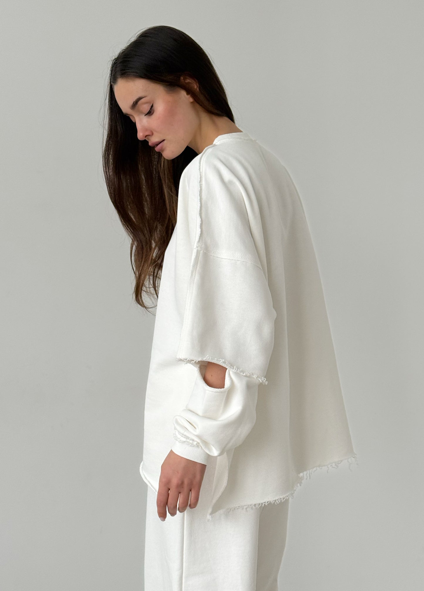 White cotton sweatshirt with a ripped elbow